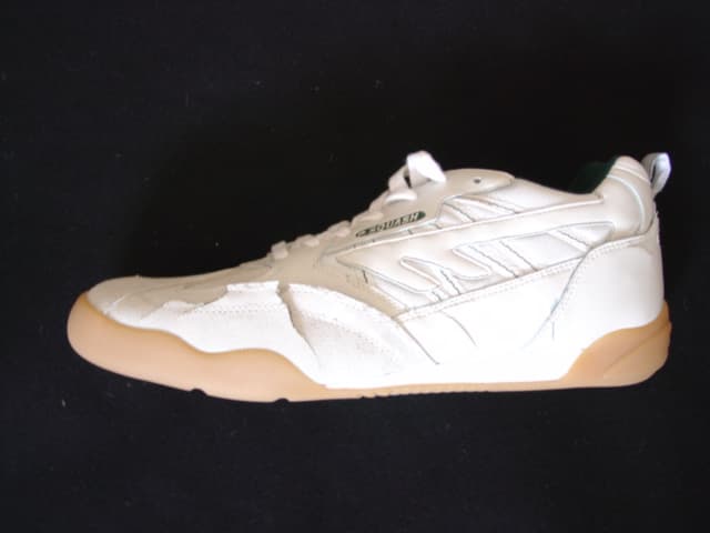 MENS TRAINING SHOE. NOT COVERING THE ANKLE. UPPERS OF TEXTILE, SUEDE AND PLASTIC. EXCLUDING REINFORCEMENTS, TEXTILE PREDOMINATES. OUTER SOLES OF RUBBER.  WITH EVA MIDSOLE DESIGNED TO ABSORB IMPACT.WITH LOGO ON HEEL, UPPER AND TONGUE. LACE UPS. INSOLE LENGTH EXCEEDING 24 CMS. CIF PRICE LESS THAN 7.5 EURO. COLOUR WHITE/GREY.