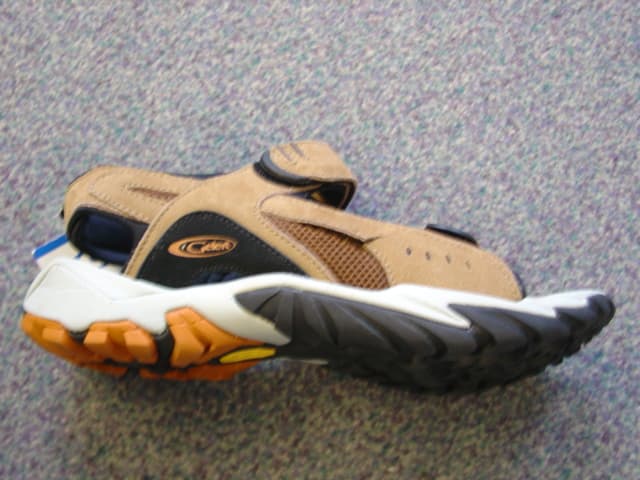 MENS SANDAL. UPPER THONG OF LEATHER AND TEXTILE MATERIAL. LEATHER PREDOMINATES. WITH 2 VELCRO FASTENING STRAPS ACROSS THE FOREFOOT AND A STRAP AROUND THE HEEL . OPEN TOED. WITH TEXTILE LINING. OUTER SOLES OF RUBBER. INSOLE LENGTH MORE THAN 24 CMS. SOLE AND HEEL HEIGHT MORE THAN 3CMS. TAN IN COLOUR.