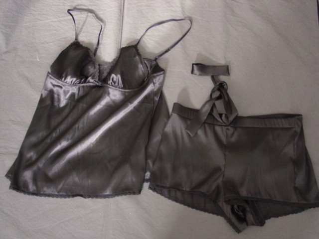 WOVEN BABY DOLL STYLE PYJAMAS FOR WOMEN.  WITH CAMISOLE VEST STYLE UPPER GARMENT AND MATCHING SHORT STYLE BRIEFS.  THE UPPER HAS ADJUSTABLE SHOULDER STRAPS.  V NECK WITHOUT OPENING, WITH SMALL DECORATIVE BOW AT THE FRONT. WITH LACE DECORATION AROUND THE NECKLINE AND AT THE BASE. THE SHORT STYLE BRIEFS HAVE A LINED GUSSET.  WITH ELASTICATION AT THE BACK OF THE WAIST AND LARGE DECORATIVE TIES AT FRONT.  WITH LACE STYLE TRIM AROUND LEG OPENINGS. 100 PERCENT POLYESTER.