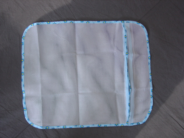 A RE-USEABLE CLOTHES WASHING LAUNDRY BAG.  MADE FROM KNITTED MAN-MADE MESH NET FABRIC.  MEASURES APPROXIMATELY 47 CM X 38 CM.  WITH ZIP FASTENED ENCLOSURE TO SECURE CLOTHES IN THE BAG. ALL SEAMS BOUND WITH FABRIC.