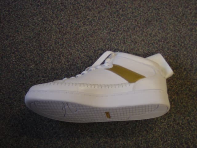 MENS BASKETBALL SHOE. COVERING THE ANKLE BUT NO PART OF THE CALF. WITH UPPERS OF LEATHER. WITH OUTER SOLES OF PLASTIC/RUBBER. WITH AN EVA MIDSOLE. WITH AN INSOLE LENGTH OF MORE THAN 24 CMS. WITH LACE UP FASTENING. WITH LOGO ON TONGUE AND ON LACES. WHITE IN COLOUR WITH A GOLD STRIP ALONG THE UPPER.