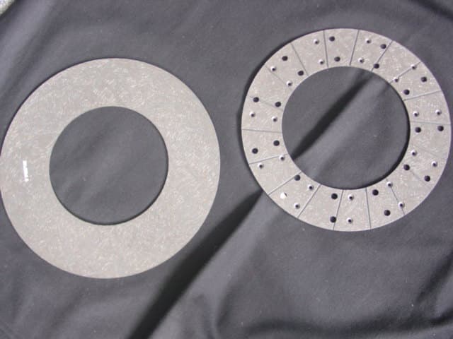 FRICTION MATERIAL.  CONSTRUCTED FROM NON FIBROUS SILICATE FILLER, ORGANIC FIBRE, CARBON BLACK, COKE, GRAPHITE, PHENOLIC RESIN, METALLIC OXIDES, GLASS FIBRE, COPPER AND OTHER FILLERS. TO BE MANUFACTURED FOR FITTING TO CLUTCH DRIVE PLATES USED ON TRUCK, BUS AND AUTOMOTIVE APPLICATIONS. SAMPLES SEEN ARE IN DISK FORM WITH CENTRES REMOVED.  WITH OUTER DIAMETRES OF 35 AND 38 CMS AND APPROXIMATELY 5MM THICK.  NOT MOUNTED