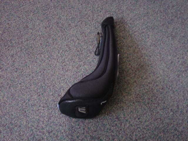 KNITTED TEXTILE GOLF HEAD COVER WITH A SMALL SECTION OF PLASTIC. SEWN IN SHAPE OF GOLF CLUBHEAD. WITH CONTRASTING PIPING AROUND THE MAIN SEAMS. WITH A ZIP OPENING DOWN THE FRONT OF THE COVER. LINED ON THE INSIDE.  WITH PRINTED LOGO AND TEXT.