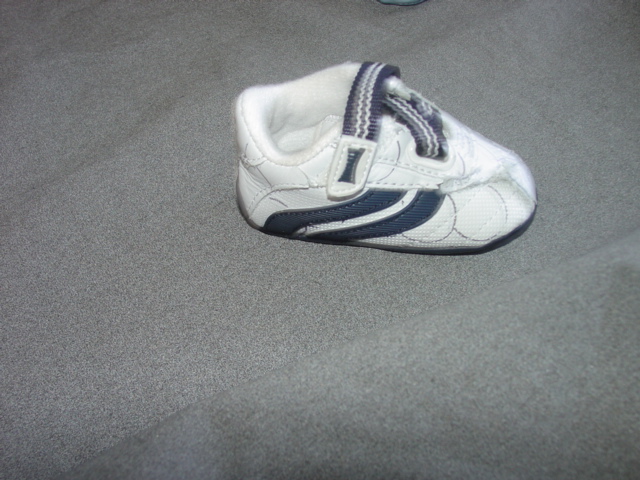 INFANTS/BABIES TRAINER STYLE SHOE. UPPERS OF WHITE LEATHER AND PLASTIC WHERE THE LEATHER PREDOMINATES. OUTER SOLES OF PLASTIC. NOT COVERING THE ANKLE. INSOLE LENGTH LESS THAN 24CMS. WITH VELCRO FASTENING TEXTILE STRAP. COMPANY LOGO ON TONGUE AND HEEL.