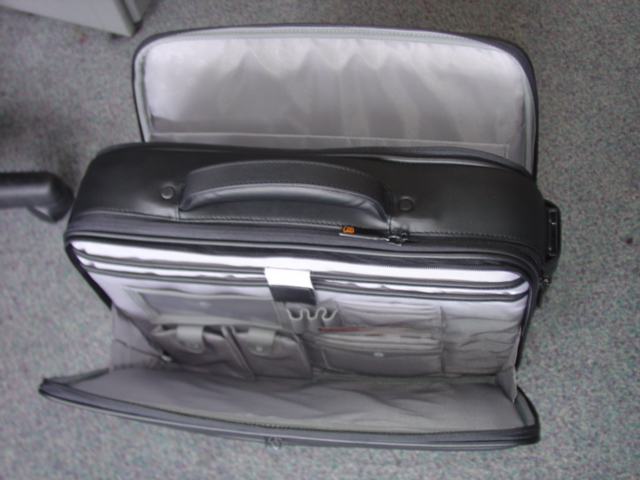 AN EXECUTIVE LAPTOP CASE. WITH THREE ZIPPED COMPARTMENTS ALL WITH ZIP FASTENINGS. THE CENTRE COMPARTMENT IS PADDED AND DESIGNED TO HOLD A LAPTOP WITH VELCRO SECURE STRAP. ONE OUTER POCKET FOR HOLDING VARIOUS ITEMS SUCH AS CARDS, PENS, DOCUMENTS, MOBILE PHONE ETC. AND A COMPARTMENT WITH A LARGE  FILE SECTION WITH TWO DIVIDERS. WITH A CARRY HANDLE AND SHOULDER STRAP. MADE OF LEATHER.