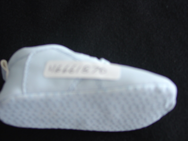 A BABY BLUE LACE UP SHOE FOR BABIES. WITH A TERRY TOWELLING LINING. WITH A SOLE OF SHEET PLASTIC WITH PLASTIC DOTS. NOT CONSIDERED TO BE SUBSTANTIAL ENOUGH TO BE AN OUTDOOR SHOE.