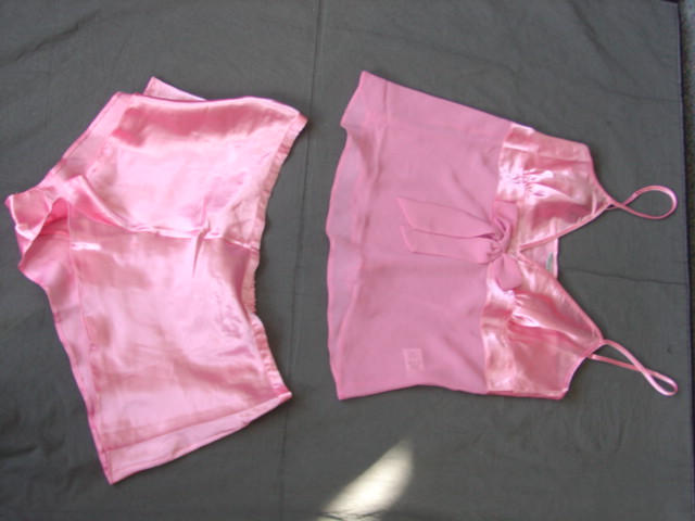 WOVEN BABY DOLL STYLE PYJAMAS FOR WOMEN.  OF SATIN LOOK FABRIC. CONSISTING OF UPPER GARMENT. REACHING DOWN TO BELOW THE WAIST. WITH V-NECK. WITHOUT OPENING.  WITH NARROW, ADJUSTABLE SHOULDER STRAPS.  THE GARMENT IS MADE FROM SHEER FABRIC BENEATH THE BUSTLINE, WITH A MATCHING BOW AT CENTRE FRONT. PACKED WITH MATCHING SATIN LOOK SHORTS.  ELASTICATED AT BACK OF WAIST WITHOUT OPENING.  HEMMED AT LEG OPENINGS.  OF POLYESTER