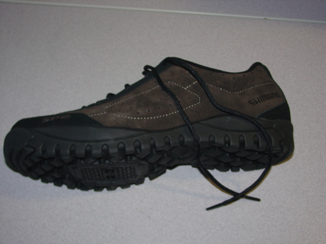 CYCLING SHOE. NOT COVERING THE ANKLE. UPPERS OF LEATHER. OUTER SOLES OF RUBBER. WITH PROVISIONS FOR PEDAL CLEATS. WITH A SCREW FASTENING REMOVEABLE COVER. LACE UPS. WITH LOGO ON UPPER. INSOLE LENGTH EXCEEDING 24CMS. BLACK/DARK BROWN IN COLOUR.