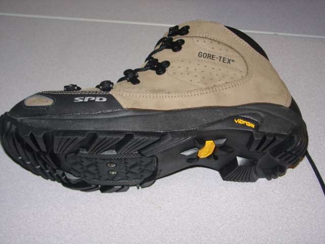 CYCLING SHOE. COVERING THE ANKLE. UPPERS OF LEATHER AND PLASTIC. LEATHER PREDOMINATES. OUTER SOLES OF RUBBER. WITH PROVISIONS FOR PEDAL CLEATS. WITH A SCREW FASTENING REMOVEABLE COVER. LACE UPS. WITH LOGO ON UPPERS. INSOLE LENGTH EXCEEDING 24CMS. BLACK/BEIGE IN COLOUR.