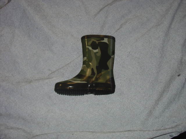 CHILDRENS PAIR OF WATERPROOF WELLINGTON BOOTS. COVERING THE ANKLE BUT NOT COVERING THE KNEE. MOULDED FROM PVC . WITH A CAMAFLAGE DESIGN WITH AN APPLIED MOTIF OF A CAR. WITH THICK TREAD ON THE SOLES. PACKAGED WITH AN UMBRELLA AND A PVC RAINMAC IN A PLASTIC SHEETING RUCKSACK WHICH HAVE ALL BEEN CLASSIFIED SEPARATELY.
