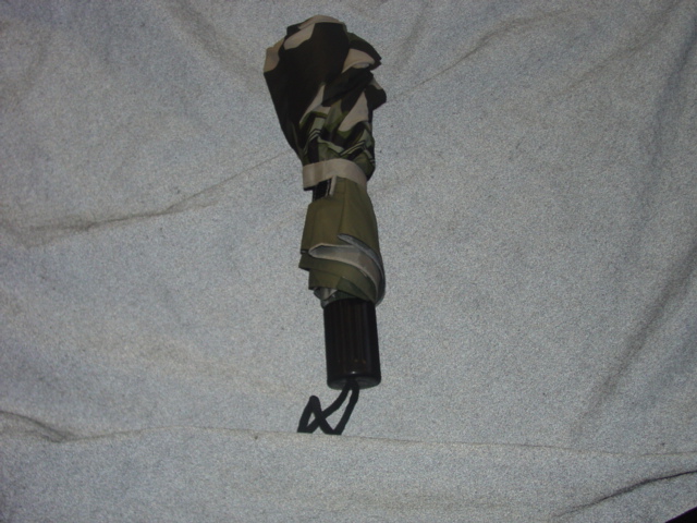 A CHILDS UMBRELLA. WITH A TELESCOPIC SHAFT. MADE FROM PVC WITH A METAL SHAFT AND PLASTIC HANDLE. WITH A CAMOFLAGE AND CAR PRINTED DESIGN. PACKAGED TOGETHER WITH A PAIR OF WELLINGTON BOOTS AND A PVC RAINMAC IN A PLASTIC SHEETING RUCKSACK WHICH HAVE ALL BEEN CLASSSIFIED SEPARATELY.