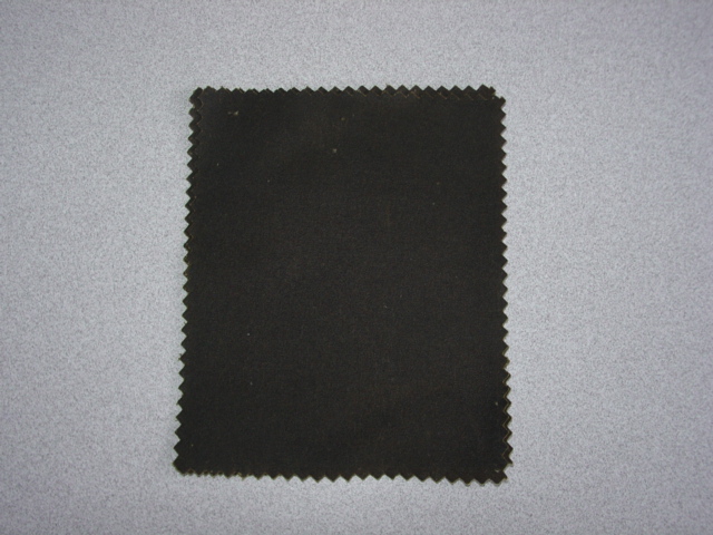 WOVEN COTTON FABRIC.  DYED OLIVE IN COLOUR.  PLAIN WEAVE. WEIGHS 280 GMS PER METRE SQUARED. SAID TO HAVE BEEN TREATED WITH WAX, WHICH IS NOT CONSIDERED TO BE VISIBLE TO THE NAKED EYE.