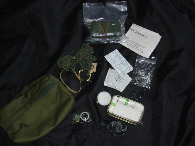 A SURVIVAL KIT. THE KIT CONTAINS A FOIL BLANKET, A TEALIGHT CANDLE, 4 PLASTIC SUSPENDER CLIPS, A SMALL COMPASS, 2 NYLON CORDS, A RAZORBLADE, A WIRE SAW, SNAREWIRE, AN ELASTIC BAND, AN INSTRUCTION BOOKLET AND A SMALL FISHING KIT CONTAINING LINE, WEIGHTS AND HOOKS. IN THE SET IS A SMALL TIN CONTAINING  20 WATER PURIFYING TABLETS, 2 TAMPONS, 2 PROTECTIVE UNLUBRICATED CONDOMS, A FLINT AND STEEL, A BALL OF COTTON WOOL AND FIRE MAKING BLOCKS. ALL PACKAGED TOGETHER IN SEALED PLASTIC RIP BAGS AND THEN PACKAGED IN A TEXTILE BAG.