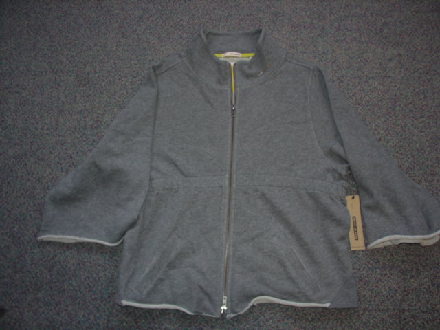 A LADIES KNITTED JACKET. DESIGNED TO COVER THE UPPER PART OF THE BODY FROM THE SHOULDERS TO THE WAIST. WITH AN ELASTICATED WAISTBAND. WITH 3 QUARTER LENGTH WIDE SLEEVES. WITH FULL ZIP OPENING. WITH COLLAR. WITH 2 POCKETS BELOW THE WAIST. MADE FROM 100 PER CENT COTTON.