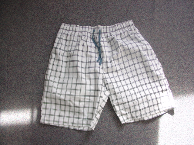 A PAIR OF UNISEX WOVEN SHORTS. OF COTTON. REACHING DOWN TO THE KNEE. WITHOUT OPENING. WITH AN ELASTICATED WAISTBAND AND DRAWSTRING TIGHTENING. WITH TWO SIDE SLIT POCKETS AND ONE REAR POCKET. HEMMED. MESH LINED. WITH CHECK DESIGN PATTERN.