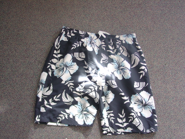 A PAIR OF UNISEX WOVEN SHORTS. OF COTTON. REACHING DOWN TO THE KNEE. WITHOUT OPENING. WITH AN ELASTICATED WAISTBAND AND DRAWSTRING TIGHTENING. WITH TWO SIDE SLIT POCKETS AND ONE REAR POCKET. HEMMED. MESH LINED. WITH FLORAL DESIGN PATTERN.