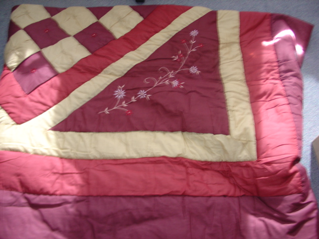 A WOVEN QUILTED BEDSPREAD. MADE FROM 80 PER CENT POLYESTER 20 PER CENT COTTON. WITH A THIN LATER OF POLYESTER WADDING. DECORATED WITH EMBROIDED FLOWERS