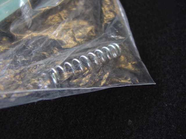 STEEL COIL COMPRESSION SPRING.  ELECTROPLATED FINISH.  MEASURING LENGTH  25 MM AND DIAMETER  5 MM.  PART OF RESTRAINT FOR WHEELCHAIR