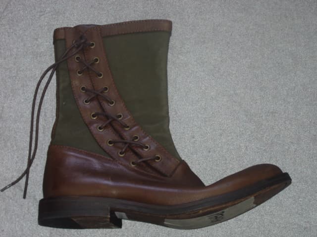 A BOOT FOR MEN, COVERING THE ANKLE BUT NO PART OF THE CALF. THE VIABLE UPPER, REACHING TO THE SOLE IS OF LEATHER, WITH THE UPPER PART OF CONTRASTING COTTON CANVAS. WITH A LACE UP FASTENING TO THE OUTER SIDE. WITH LEATHER EYESTAYS, TONGUE AND TRIM. WITH LEATHER SOLES.