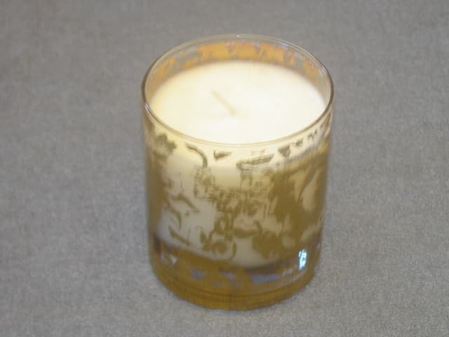 SCENTED CANDLE. MOULDED INTO A DECORATED GLASS HOLDER. SCENT: GARDENIA, TUBEROSE AND JASMINE. CANDLE WEIGHT 200 GRAMS (7 OUNCES). HEIGHT 90 MM.