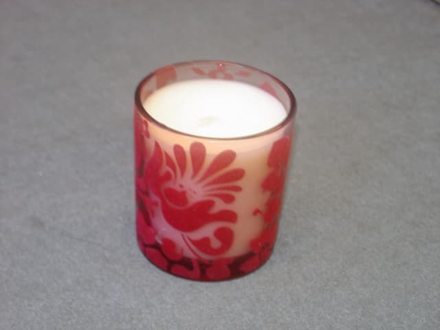 SCENTED CANDLE. MOULDED INTO A DECORATED GLASS HOLDER. SCENT: LEMON. HEIGHT 80 MM.
