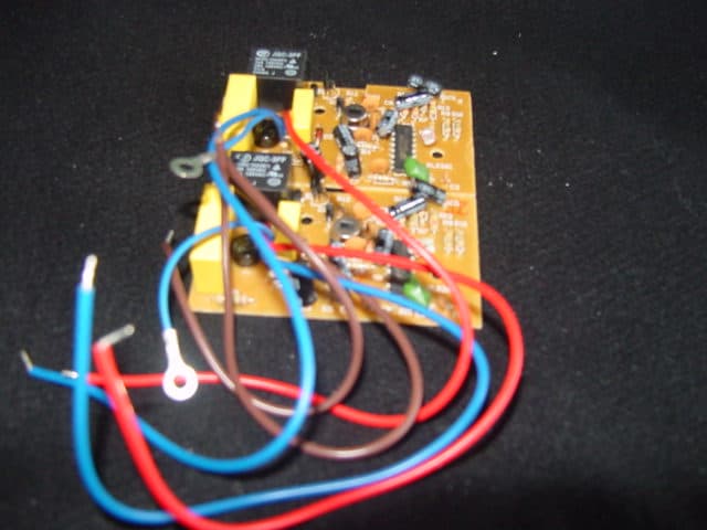 A FULLY POPULATED PRINTED CIRCUIT BOARD WHICH IS PARTS OF CONTROL APPARATUS FOR LIGHTING.  MEASURING 3.5 X 3 INCHES WITH BROWN, RED AND BLUE WIRING WITH ATTACHMENTS FITTED.