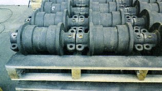 CAST STEEL ROLLERS WHICH ARE PART OF A MACHINE TRACK, TO BE FITTED TO A MINERAL CRUSHING MACHINE.  SPECIFICALLY SHAPED AND DESIGNED TO FIT A PARTICULAR MODEL.