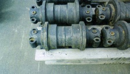 CAST STEEL ROLLERS WHICH ARE PART OF A MACHINE TRACK, TO BE FITTED TO A MINERAL CRUSHING MACHINE.  SPECIFICALLY SHAPED AND DESIGNED TO FIT A PARTICULAR MODEL.