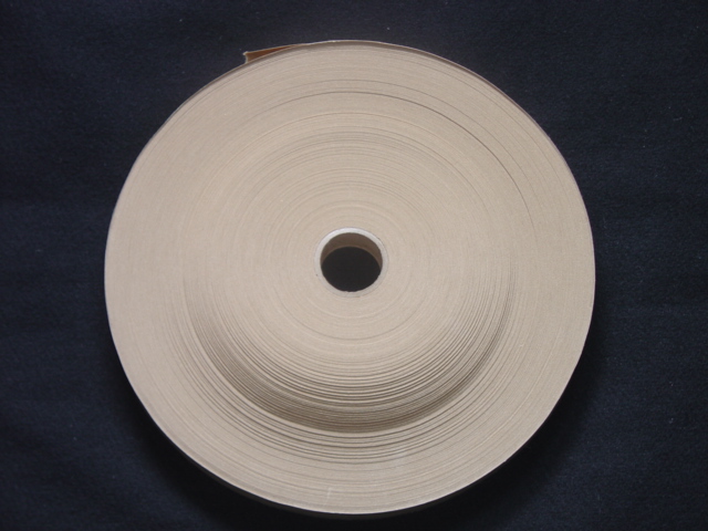 A ROLL OF GUMMED PAPER. COATED ON ONE SIDE ONLY. MEASURING 19MM WIDE. WITH PAPERBOARD INNER. BROWN IN COLOUR.