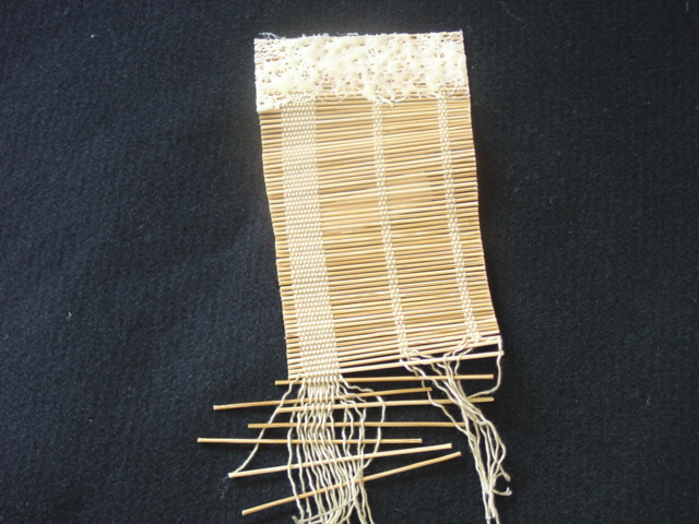 POPLAR STRIPS IN PARALLEL INTERLACED WITH A POLYESTER WEBBING TO HOLD THE STRIPS TOGETHER. USED TO MANUFACTURE WINDOW BLINDS/SCREENS.