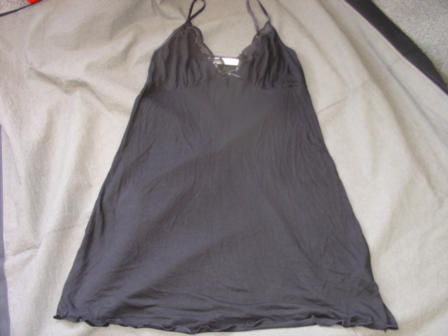 A KNITTED PETTICOAT FOR LADIES DESIGNED TO COVER THE BODY FROM THE SHOULDERS TO JUST ABOVE THE KNEE. WITH V NECKLINE AT THE FRONT BUT STRAIGHT ACROSS THE BACK AT  ARMPIT LEVEL.  WITH LACE STYLE EDGE AND RIBBON BOW AROUND FRONT NECKLINE. WITH BOUND EDGES ROUND TOP OF GARMENT. FLUTED HEM. WITH NARROW ADJUSTABLE RIBBON SHOULDER STRAPS. 95 PER CENT MODAL, 5 PER CENT SPANDEX.