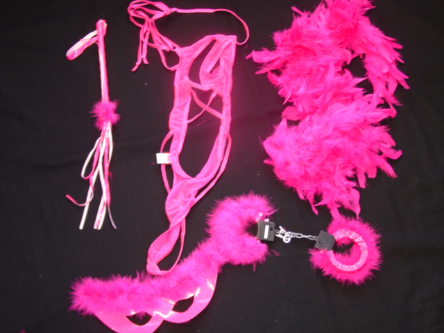 A LADIES KNITTED UNDER GARMENT. DESIGNED TO COVER THE BODY FROM THE SHOULDERS TO THE CROTCH. MADE FROM KNITTED MESH AND ELASTICATED STRAPS.MADE FROM 92 PER CENT ELASTANE 8 PER CENT NYLON. WITH TIE AROUND THE BACK AND HALTER NECK STRAPS. PACKAGED TOGETHER WITH A WHIP, TEXTILE FACEMASK, FEATHER BOA, NOVELTY HANDCUFFS AND A SMALL DRAWSTRING STORAGE BAG, PACKAGED IN A PLASTIC BAG WITH HANGER.