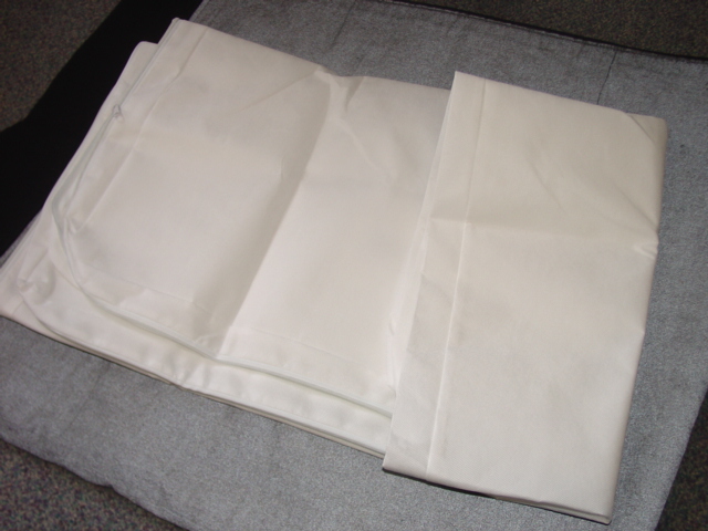 A TEXTILE FITTED MATTRESS PROTECTOR. DESIGNED TO FIT OVER THE MATTRESS FOR PROTECTION. MADE FROM NONWOVEN POLYPROPYLENE. WITH ZIP FASTENING.
