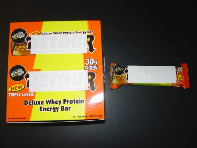 A CHOCOLATE COATED WHEY PROTEIN BAR, INGREDIENTS : WHEY PROTEIN 20%, CHOCOLATE COATING 15%, WATER, GLYCERINE, PEANUTS 10%, CARAMEL 10%, SOY PROTEIN ISOLATE, GELATIN, CALCIUM CASEINATE, INULIN, PEANUT FLAVOUR, RICE FLOUR, SOYBEAN OIL, SALT, PRESERVATIVE, SWEETENER.