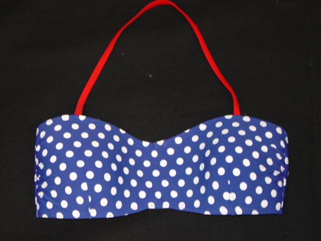 WOMENS KNITTED PADDED BRASSIERE.  WITH HALTER STYLE  STRAP. WITH OPENING AT THE BACK.  WITH PLASTIC CLASP FASTENING.  ELASTICATED AND HEMMED AT ALL EDGES.  MADE OF 80 PERCENT NYLON AND 20 PERCENT ELASTANE.