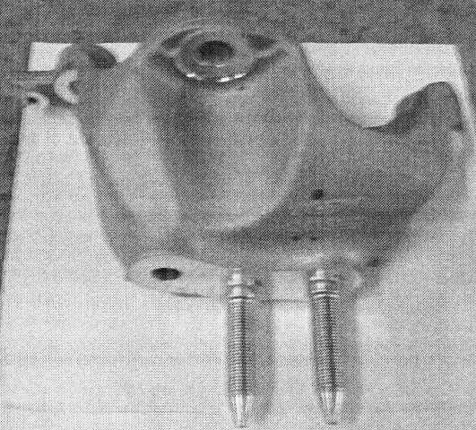 BASE BRACKET TRANSMISSION MOUNTING (AT). THE PART IS A BRACKET LOCATED BETWEEN THE VEHICLE BODY AND THE AUTOMATIC TRANSMISSION ELEMENTS. THE PART IS MADE OF CAST ALUMINIUM, PREDRILLED AND MACHINED. THE PART INCORPORATES TWO LONG THREADED STEEL PRONGS FOR AFFIXING THE BRACKET TO THE VEHICLE BODY. THE PART IS DESIGNED TO BEAT THE WEIGHT OF THE AUTOMATIC TRANSMISSION ELEMENTS AND FIX THEM SECURELY WITHIN THE VEHICLE. THE PART HAS MACHINED AND POLISHED HOLES WHICH ALIGN WITH OTHER PARTS AND FITTINGS IN THE COURSE OF MANUFACTURING. THESE HELP TO ATTACH THE BRACKET IN THE APPROPRIATE PLACE WITHIN THE VEHICLE. THE PART IS IMPORTED FOR THE INDUSTRIAL ASSEMBLY OF AUTOMOBILES.
