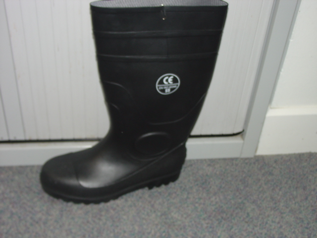 WATERPROOF SAFETY WELLINGTON BOOT. COVERING THE ANKLE. UPPERS AND OUTER SOLES OF PLASTIC AND RUBBER. THE UPPERS ARE NEITHER FIXED TO SOLE NOR ASSEMBLED BY STITCHING OR RIVETING. WITH A PROTECTIVE METAL TOE-CAP. BLACK IN COLOUR.