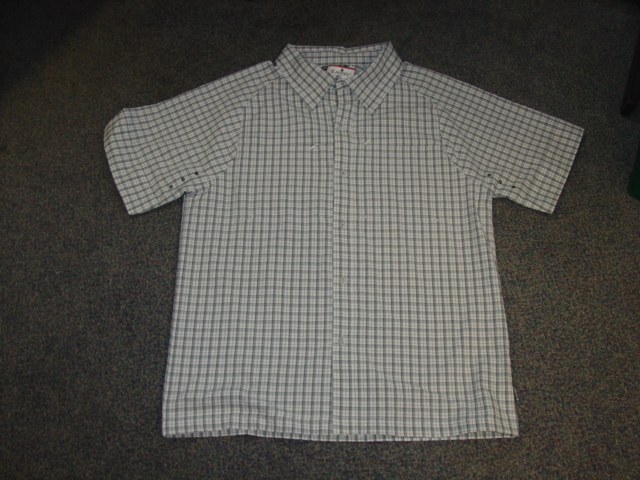 WOVEN SHIRT FOR MEN. REACHING DOWN TO BELOW THE WAIST.  ROUND NECK WITH COLLAR. COMPLETE FRONT OPENING FASTENED LEFT OVER RIGHT BY BUTTONS. SHORT SLEEVES. HEMMED AT SLEEVE ENDS AND AT BASE OF GARMENT.  WITH ZIPPED POCKETS AT CHEST.  68 PERCENT POLYESTER AND 32 PERCENT NYLON