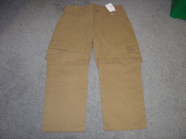 WOVEN TROUSERS FOR MEN.  REACHING DOWN TO THE ANKLES. CAN BE MADE SHORTER BY REMOVING LOWER PART OF LEGS WHICH ARE ATTACHED BY  ZIPS.  LEFT OVER RIGHT ZIP FLY FASTENING WITH SINGLE BUTTON AT WAISTBAND. ZIPPED POCKETS AT FRONT, BUTTON FLAP POCKETS AT BACK AND VELCRO FLAP POCKETS ON LEGS.  HEMMED AT LEG ENDS. OF COTTON.
