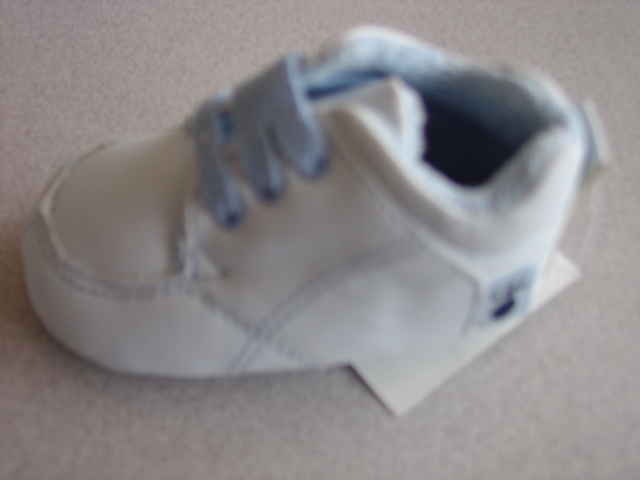 A BABY BLUE LACE UP SHOE FOR BABIES. WITH A TERRY TOWELLING LINING. WITH AN UPPER AND OUTER SOLE OF PLASTIC WITH PLASTIC PAW PRINTS DECORATING THE OUTER SOLE. WITH A TEXTILE PAW PRINT ON THE SIDE.