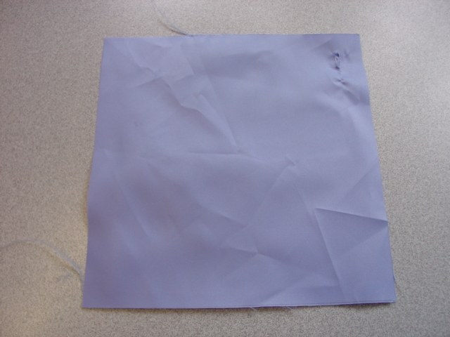 WOVEN FABRIC OF 100 PERCENT POLYESTER FILAMENT YARNS.  NOT HIGH TENACITY YARNS AND NON TEXTURED YARNS. PLAIN DYED BLUE IN COLOUR. SAID TO BE TREATED WITH PTFE TO MAKE WATERPROOF, BUT THIS IS NOT VISIBLE TO THE NAKED EYE. INTENDED USE IS FOR MAKING INTO SURGICAL GOWNS AND TABLE COVERINGS FOR OPERATING THEATRES IN HOSPITALS. ALSO COVERINGS AND DRAPES FOR PATIENTS AND CLEAN AIR SCRUB SUITS.