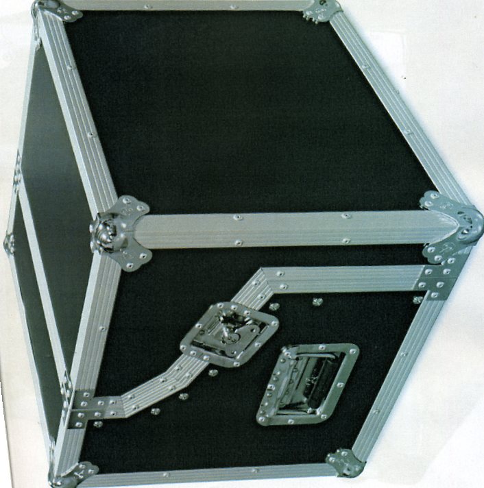 A PVC COATED TRUNK SQUARE IN SHAPE MANUFACTURED FROM A PLYWOOD SHELL COVERED WITH PLASTIC SHEETING. EDGES ARE PROTECTED BY ALUMINIUM EXTRUSIONS, RIVETED TO THE PLYWOOD SHELL. WITH ZINC OR CHROME PLATED HANDLES , CATCHES, CORNERS, HINGES AND WHEELS RIVETED TO THE CASE. LINED WITH POLY FOAM FOR PROTECTION OF GOODS. 560(L) X 560 (D) X 550 (H).