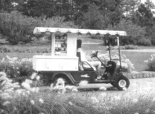 PETROL DRIVEN CART WITH FOUR WHEELS, CANOPY AND SERVING SECTION AT THE REAR.  FRAME: WELDED STEEL WITH POWDER COAT FINISH.  FRONT BODY AND FINISH: INJECTION MOULDED.  REAR BODY AND FINISH: STEEL, BASE COAT/CLEAR COAT.  STANDARD COLOUR: HUNTER GREEN.  POWER SOURCE: 4 CYCLE 401 CC PETROL ENGINE.  HORSEPOWER: 13 HP.  SEATING CAPACITY: 2 PERSONS.  DRY WEIGHT (WITHOUT BATTERIES): 606 KG.  OVERALL LENGTH: 2807 MM.  OVERALL WIDTH: 1265 MM.  OVERALL HEIGHT: 1829 MM (WITH CANOPY), 1234 MM (TO TOP OF STEERING WHEEL).  WHEEL BASE: 1956 MM.