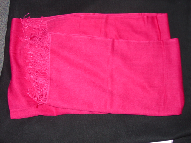 A WOVEN SHAWL/PASHMINA MADE FROM 53 PERCENT SILK AND 47 PERCENT CASHMERE. HEMMED WITH FRINGES AT EACH END. MEASURES 56CM WIDE 184CM LONG. CERISE IN COLOUR.