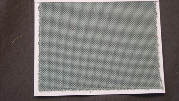 A  WOVEN FABRIC OF 75 PER CENT SILK AND 25 PER CENT COTTON. YARNS OF DIFFERENT COLOURS. WIDTH 142.3 CM. 405 GMS PER SQ MTR. BLUE-GREEN IN COLOUR.