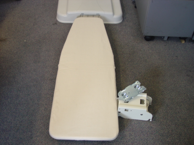 A PAINTED WALL MOUNTED FOLDING IRONING BOARD MADE OF STEEL MESH. WITH  ZINC ALLOY HINGES THAT ALLOW BOARD TO LIE PERFECTLY FLAT.  NEUTRAL COLOUR. INCLUDES A PLASTIC ABS COVER.  STEEL COATED STRUCTURE SWIVELS AND LOCKS.