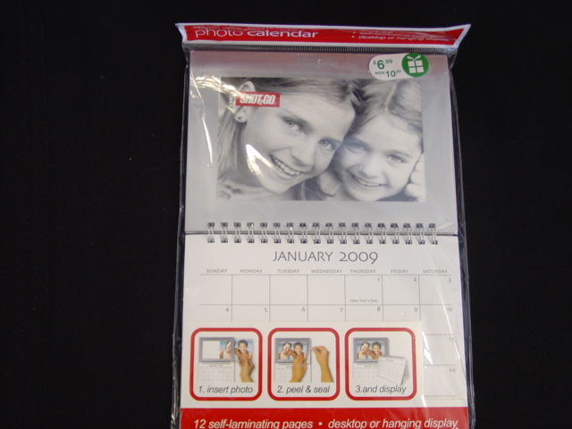 PHOTO CALENDER.  THE CALENDER HAS A FACILITY  TO HOLD TWELVE PHOTOS ONE FOR EACH MONTH OF THE YEAR. THE PHOTOS HOLDER HAS A SELF LAMINATING PEAL AND SEAL. SPIRAL BOUND. MEASURING 126 MM BY 180 MM.