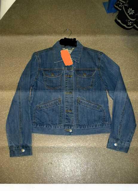 A WOVEN 100 PERCENT COTTON DENIM JACKET FOR LADIES DESIGNED TO COVER THE UPPER PART OF THE BODY TO JUST BELOW THE WAIST. WITH COMPLETE OPENING FASTENED RIGHT OVER LEFT WITH BUTTONS. WITH TWO BREAST POCKETS AND TWO SLIT POCKETS TO FRONT OF GARMENT WITH LONG SLEEVES FASTENED AT CUFF WITH PRESS STUDS. WITH COLLAR.