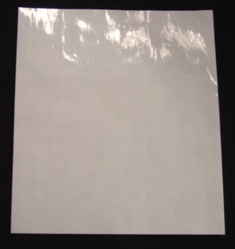 SELF ADHESIVE POLYETHYLENE FILM IN ROLLS OF A WIDTH EXCEEDING 20 CM.  THE FILM CAN BE TRANSPARENT (CLEAR) OR WHITE.  THICKNESS OF THE FILM  IS  BETWEEN 40 MICRONS TO 60 MICRONS. THERE IS A PRESSURE SENSITIVE SYNTHETIC RUBBER ADHESIVE ON ONE SIDE OF THE FILM WHICH HAS AN APPLICATION RATE NOMINALLY OF 15 GSM , RANGE +/- 50%. THE ADHESIVE SIDE IS IN CONTACT WITH A BACKING PAPER MADE FROM GLASSINE, THE ADHESIVE CONTACT SIDE OF WHICH HAS BEEN SILICONE COATED.  THE BACKING PAPER HAS A NOMINAL WEIGHT OF  90 GSM, RANGE +/- 50%  AND IS SOLELY USED AS A METHOD OF TRANSPORT FOR THE FILM.   THE FILM  IS USED FOR THE MANUFACTURE OF SMALL PRINTED, SELF ADHESIVE LABELS. THE LABELS BEING  MADE USING A FLEXOGRAPHIC PRINTING PROCESS.