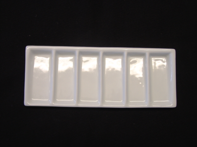 A PORCELAIN PALETTE, USED AS A PAININTING PALETTE FOR MIXING COLOURS. WITH 6 PARTITIONS. DIMENSIONS 19CM LENGTH X 7CMWIDTH